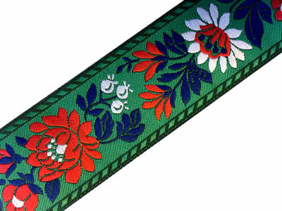 Zelená krojová stuha s bílomodrým květinovým vzorem - vzorovka š 3,5 cm. Textilní tkaná stuha se vzorem modrých a bílých květů je vhodná zvláště k lemování tkanin, zdobení krojů a šatů panenek a maňásků.