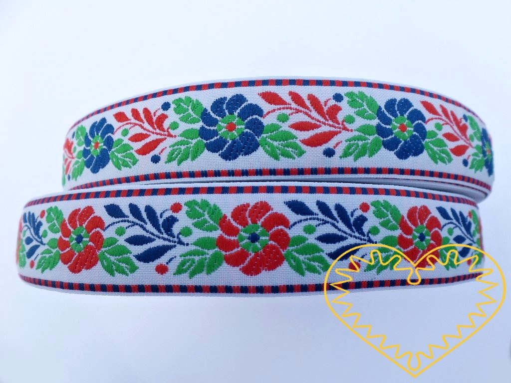 Bílá krojová stuha se vzorem - vzorovka - šíře 2,5 cm. Textilní tkaná stuha s modrými květy a červenými a zelenými lístky se uplatní zvláště při výrobě krojů a předmětů tradiční lidové kultury. Vhodná též k lemování tkanin a šatů panenek a maňásků.